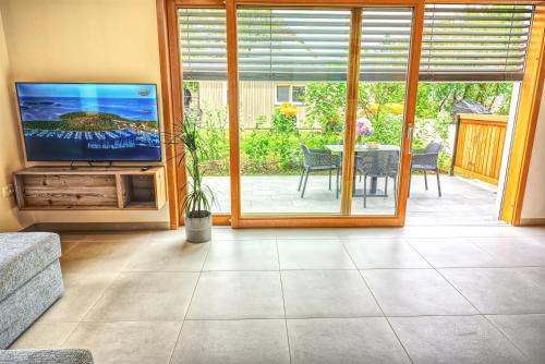 a living room with a television and a table with a dining room at House Elipsa in Bovec