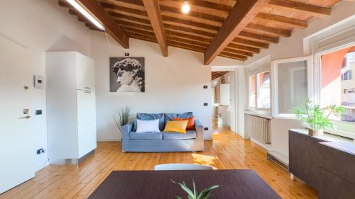 ein Wohnzimmer mit einem blauen Sofa und einem Tisch in der Unterkunft Sky View Residenza - Roofview free parking in Verona