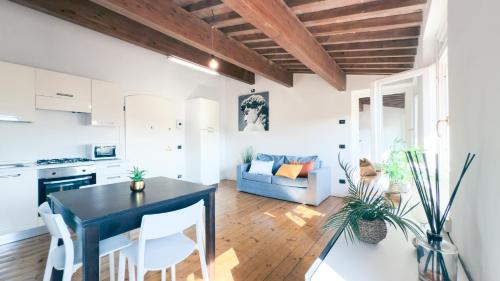 a kitchen and living room with a table and chairs at Residenza Sky View Roofview free parking in Verona