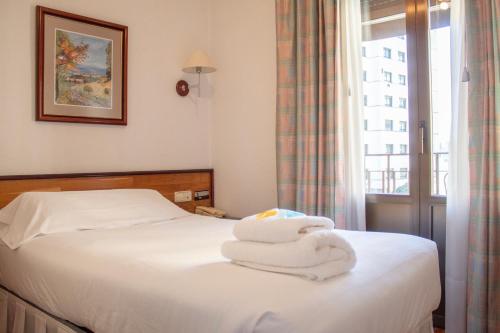 a hotel room with a bed with towels on it at Hostal Navarra in Pamplona