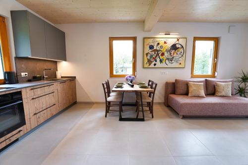 a kitchen and living room with a table and a couch at House Elipsa in Bovec