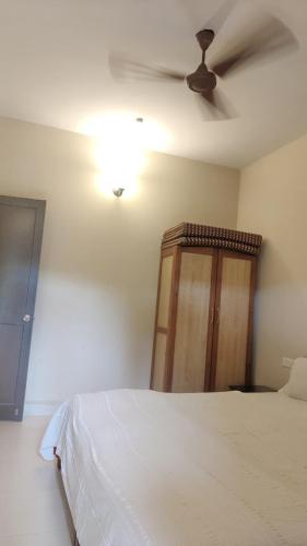 a bedroom with a bed and a ceiling fan at Candolim 4bhk Apartment Goa in Candolim