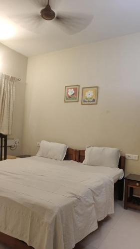 a bedroom with a large white bed with two pillows at Candolim 4bhk Apartment Goa in Candolim