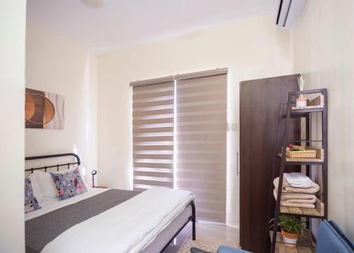 a bedroom with a bed and a window with a shutter at Holiday Home in Dauis, Panglao Island Bohol in Dauis