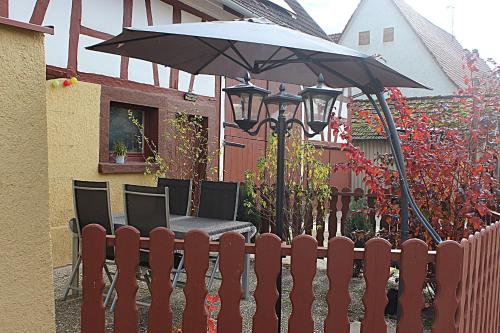 a fence with a table and an umbrella at Schöne 2 Zimmer Wohnung in Sulz Bergfelden bis 4 Personen in Sulz am Neckar