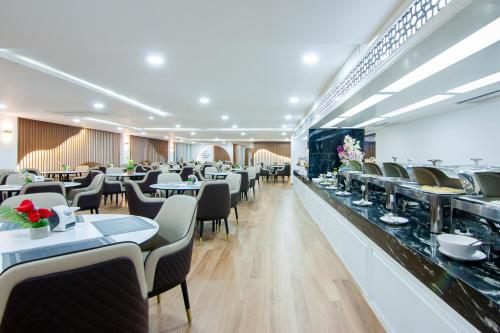 a dining room with tables and chairs in a restaurant at Golden Jomtien Beach Hotel in Jomtien Beach