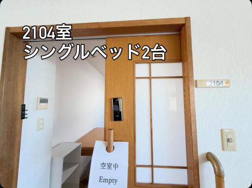 an office door with a sign that reads emergency at ハイ沖縄金武店トイレお風呂共用 プレオープン中駐車場有 ペット同伴可能長期滞在可能2025年10月より車貸し出しサービス有希望であればお申し付けください in Kin