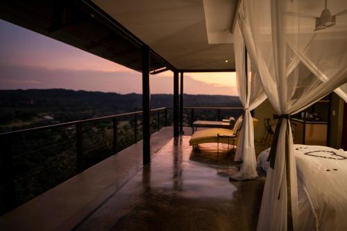 a bedroom with a bed and a balcony with a view at The Outpost in Makuleke Contract Park