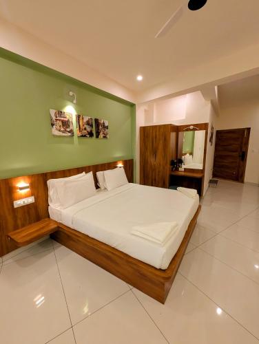 a bedroom with a bed and a green wall at Sihi Homes in Mysore