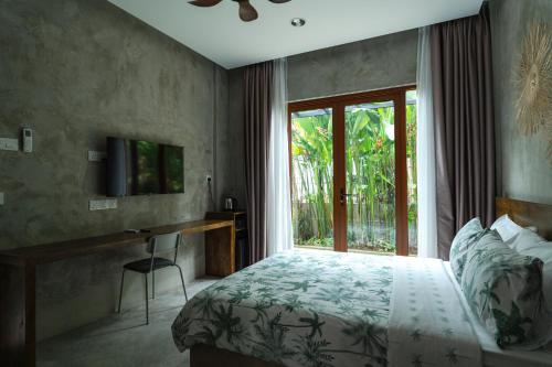 a bedroom with a bed and a desk and a window at Chrisenbel Hideaway Retreat in Petaling Jaya