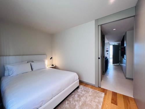 una camera con letto bianco e corridoio di Granja Premium House ad Aveiro