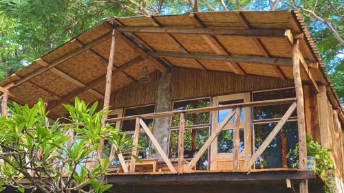 a tree house with a wooden roof at Butterfly Space- A Non-Profit Eco-Lodge in Nkhata Bay