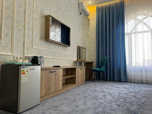 a kitchen with a refrigerator and a television on the wall at Turkistan in Türkistan