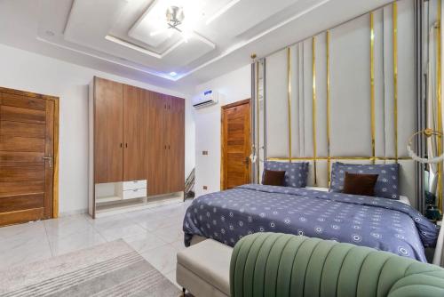 a bedroom with a blue bed and a couch at House Of Pryde in Maiyegun