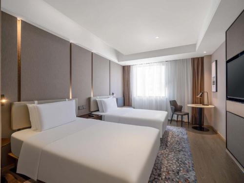 a hotel room with two beds and a television at Holiday Inn Express Zhuhai Grand Theater by IHG in Zhuhai