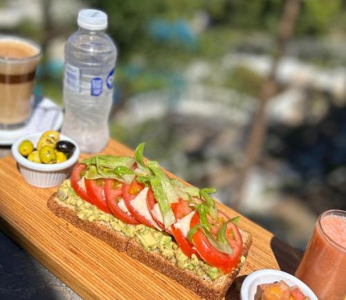 a sandwich on a cutting board with a bottle of water at Tanger Miramonte - Resort Seaside Suites & Double Rooms in Tangier