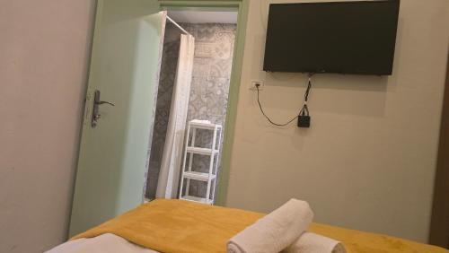 a room with a television and a bed with a window at Al Bishara Guest House in Nazareth