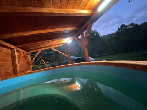 a view from the inside of a wooden house with a swimming pool at Cabana trei paltini in Poiana Vadului