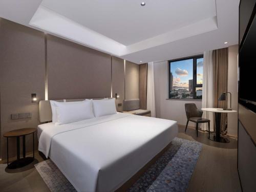 a bedroom with a large white bed and a window at Holiday Inn Express Zhuhai Grand Theater by IHG in Zhuhai