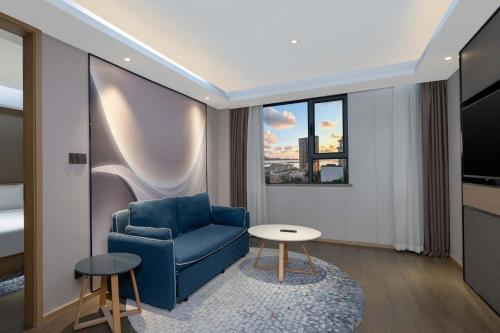 a living room with a blue chair and a table at Holiday Inn Express Zhuhai Grand Theater by IHG in Zhuhai