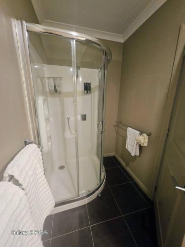 a shower with a glass door in a bathroom at Parnwell Cottage in Ohauiti