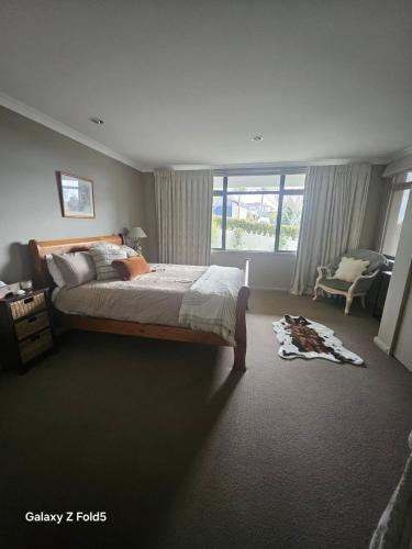 a bedroom with a large bed and a window at Parnwell Cottage in Ohauiti
