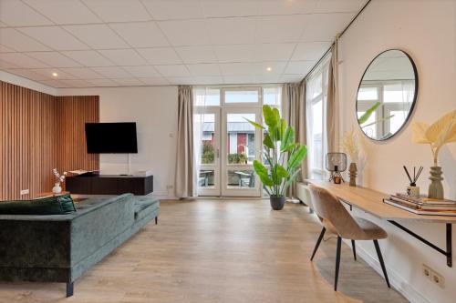 a living room with a couch and a table at The marine apartment near Amsterdam by Weltevreden Experience in Kortenhoef