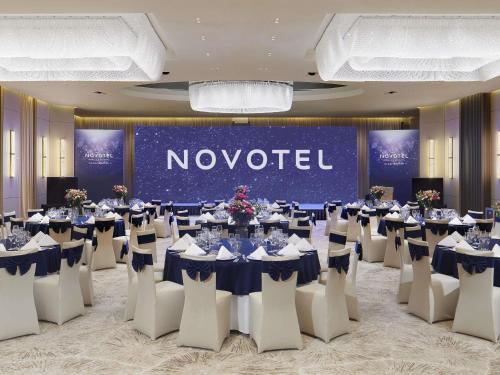 a banquet hall with tables and chairs and a novation sign at Novotel Ulaanbaatar in Ulaanbaatar