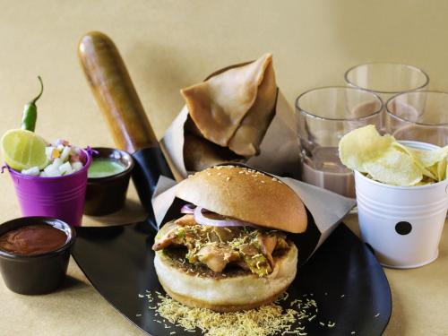 a sandwich on a plate on a table with drinks at ibis Styles Ribeirao Preto Maurilio Biagi in Ribeirão Preto