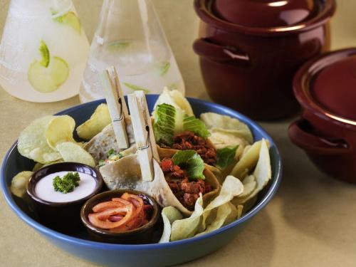 a blue bowl of food with chips and vegetables at ibis Styles Ribeirao Preto Maurilio Biagi in Ribeirão Preto