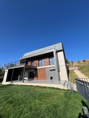 ein großes Gebäude mit einem Grasfeld davor in der Unterkunft RODNIK guesthouse in Besqaynar