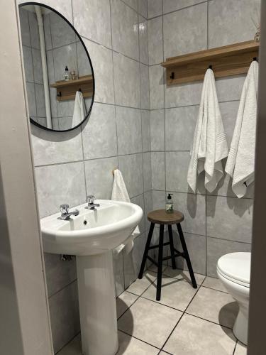 a bathroom with a sink and a toilet and a mirror at Lang Apartment in Great Brak River