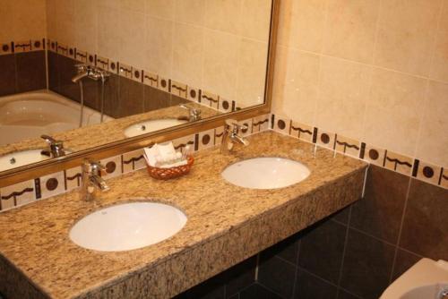 a bathroom with two sinks and a mirror at Hotel Elegance in Asenovgrad