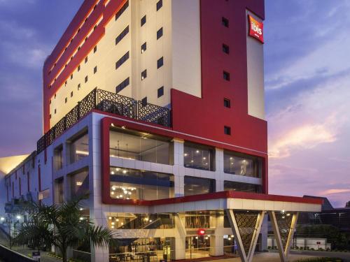 a hotel with a red and white building at ibis Pontianak City Center in Pontianak