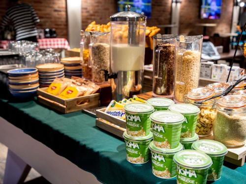 a table topped with jars of food and other foods at ibis Styles Glasgow Central in Glasgow