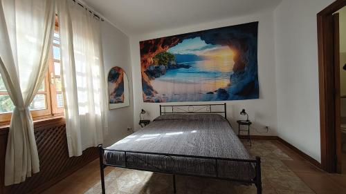 a bedroom with a bed with a painting on the wall at Tidale Host house B&B in Alghero