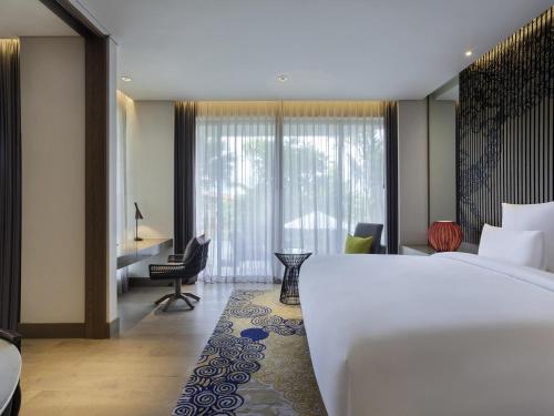a hotel room with a large bed and a desk at Pullman Ciawi Vimala Hills Resort in Bogor