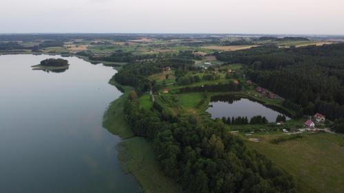 an aerial view of a lake with trees and houses at Mazurska Latarnia z prywatną plażą i stawem in Rydzówka