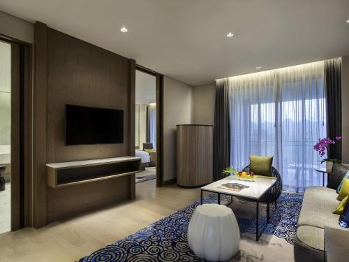 a living room with a couch and a tv at Pullman Ciawi Vimala Hills Resort in Bogor