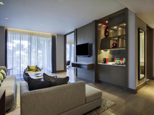 a living room with a couch and a television at Pullman Ciawi Vimala Hills Resort in Bogor