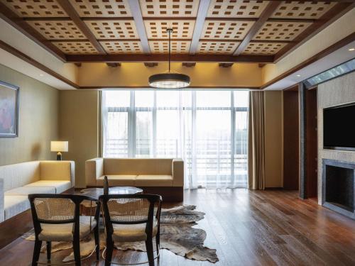 a living room with a table and chairs and a couch at Pullman Changbaishan Resort in Fusong