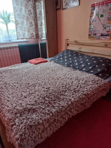 a bed with a white comforter and a window at ALEJAw in Ciechocinek