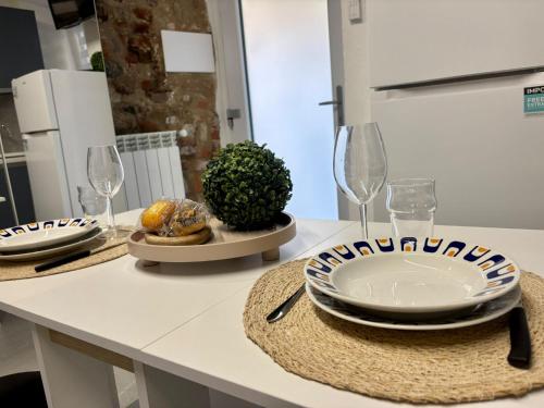 a kitchen counter with plates and wine glasses on it at HappyHome Relax di coppia in Rivarolo Canavese