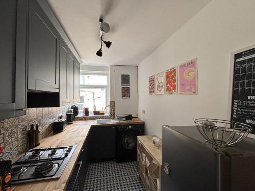 Il comprend une cuisine équipée d'une cuisinière. four supérieur à côté d'un comptoir dans l'établissement Spacious Cosy 2 Bed Flat in The Heart of Headingley, à Headingley