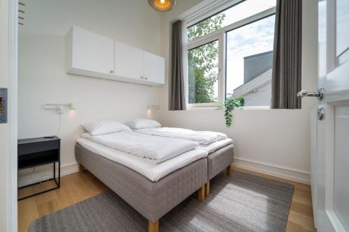 a white bedroom with a bed and a window at Hotel Lille Nyhavn in Skanderborg