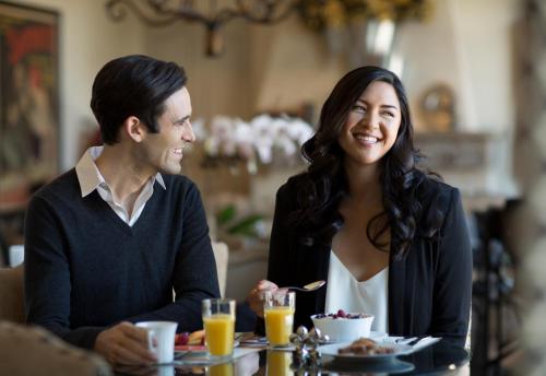 a man and a woman sitting at a table eating food at Enchante Boutique Hotel in Los Altos