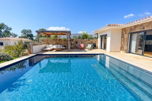 a swimming pool in the backyard of a house at Villa A Calia di Fiori Mare in Sainte-Lucie de Porto-Vecchio