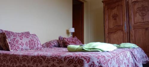 a bedroom with a bed with a red and white blanket at Hostal el Arroyito in Ushuaia