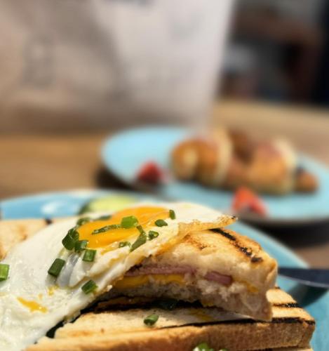 ein Frühstücks-Sandwich mit einem Ei auf einem blauen Teller in der Unterkunft MGR Pokoje w samym Centrum Warszawy by Metro Rondo ONZ - SUPER Bed Year23 in Warschau