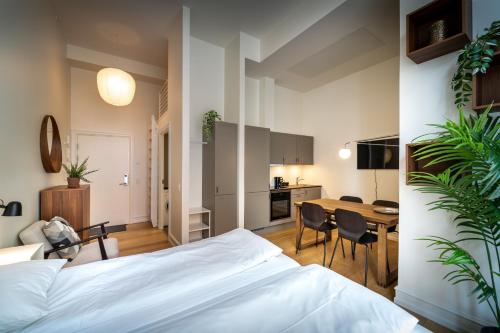 a bedroom with a bed and a table and a kitchen at Hotel Lille Nyhavn in Skanderborg